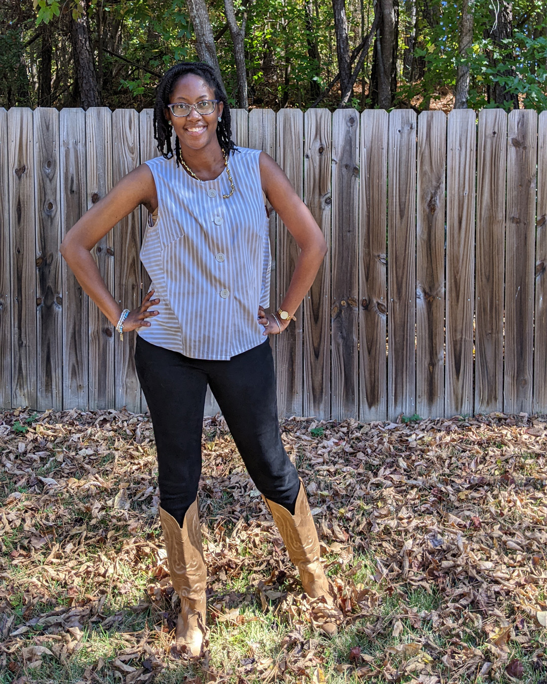Person wearing a handmade striped cotton shirt with buttons and leggings, smiling outdoors.